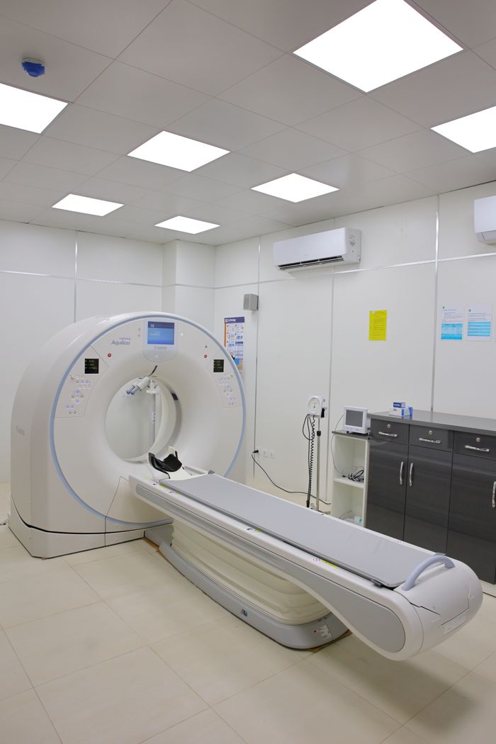 High-tech CT scanner in a bright, well-equipped hospital room for medical diagnostics.